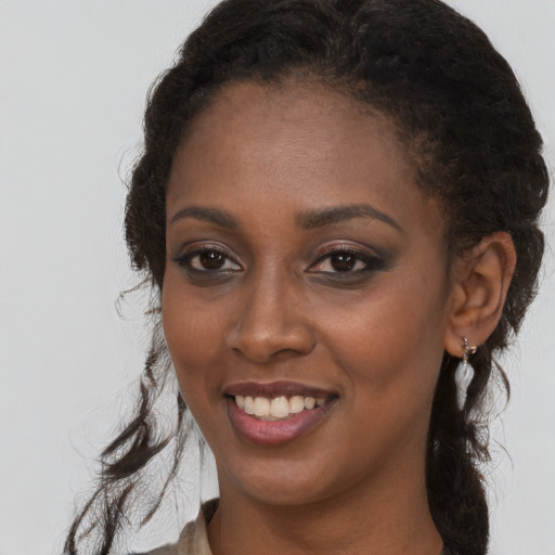 Joyful black young-adult female with long  brown hair and brown eyes