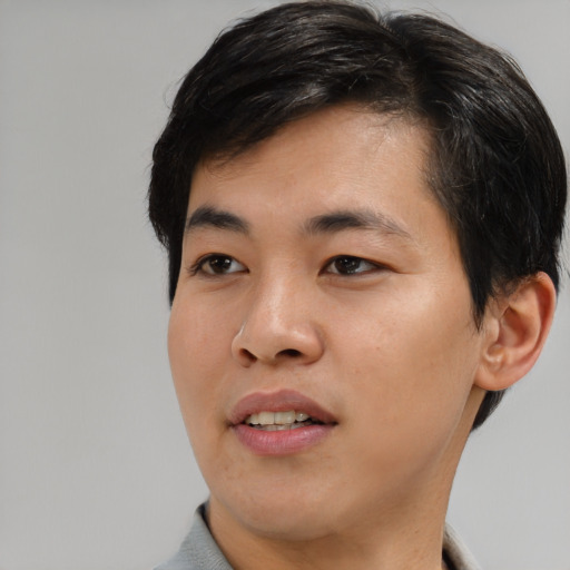 Joyful asian young-adult male with short  brown hair and brown eyes