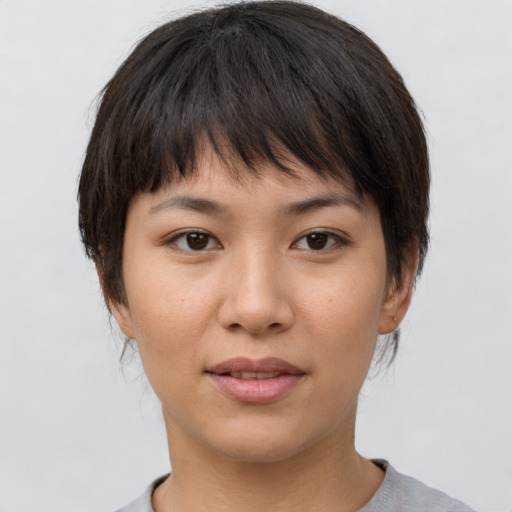 Joyful asian young-adult female with short  brown hair and brown eyes