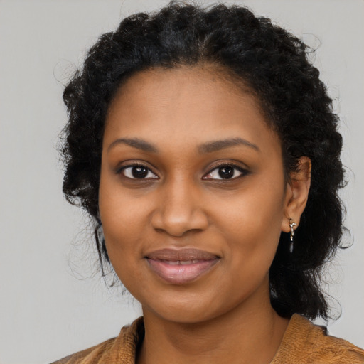 Joyful black young-adult female with long  black hair and brown eyes