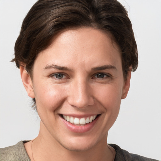 Joyful white young-adult female with short  brown hair and grey eyes