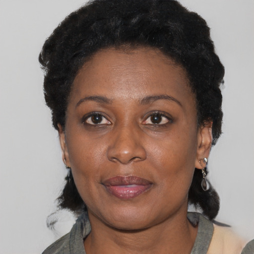 Joyful black adult female with short  black hair and brown eyes