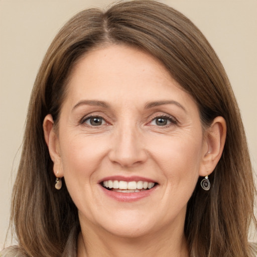 Joyful white adult female with long  brown hair and brown eyes