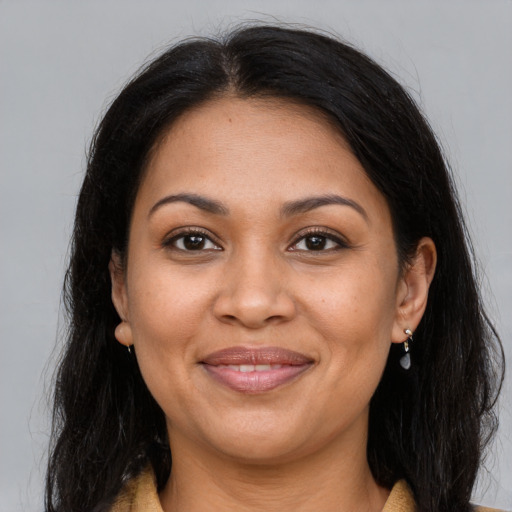 Joyful latino adult female with long  brown hair and brown eyes