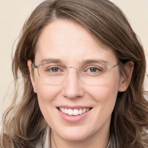 Joyful white adult female with long  brown hair and blue eyes