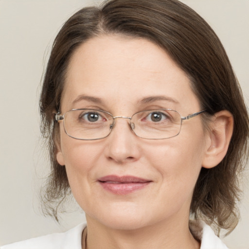 Joyful white adult female with medium  brown hair and grey eyes