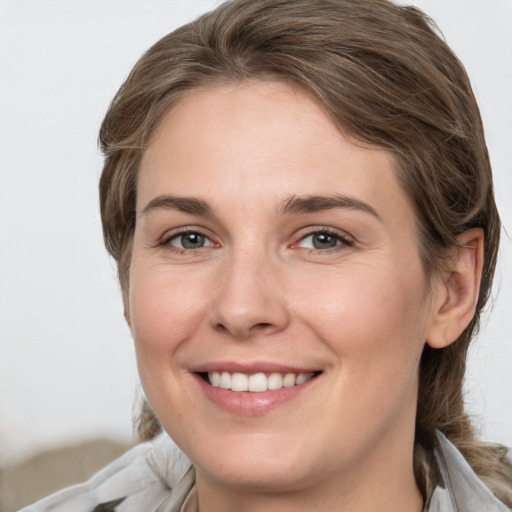 Joyful white young-adult female with medium  brown hair and grey eyes