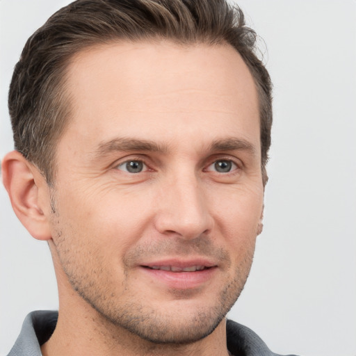 Joyful white adult male with short  brown hair and grey eyes