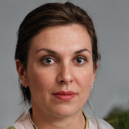 Joyful white adult female with medium  brown hair and grey eyes