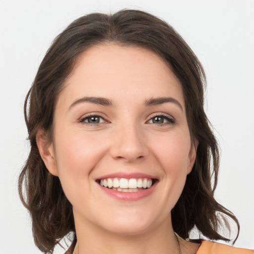 Joyful white young-adult female with medium  brown hair and grey eyes