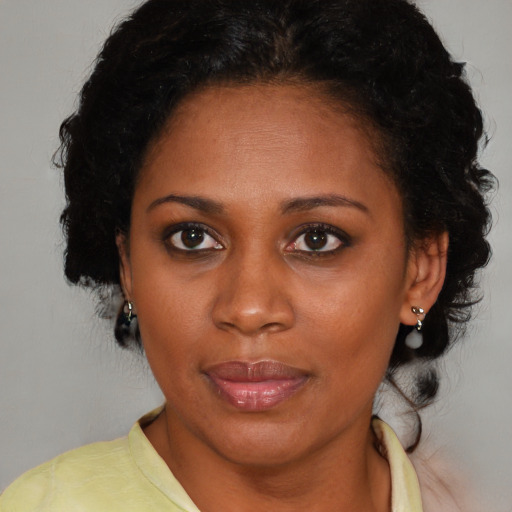 Joyful black young-adult female with medium  brown hair and brown eyes