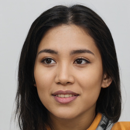 Joyful latino young-adult female with long  brown hair and brown eyes