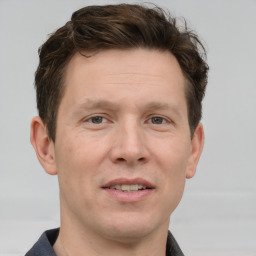 Joyful white adult male with short  brown hair and grey eyes