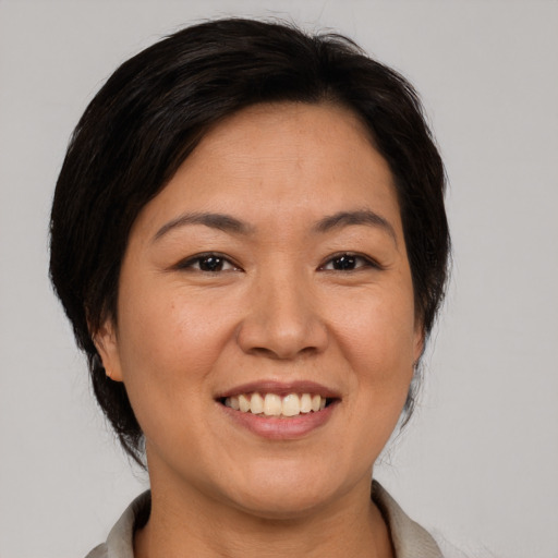 Joyful asian adult female with medium  brown hair and brown eyes