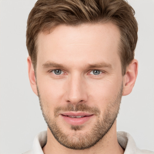 Joyful white young-adult male with short  brown hair and grey eyes