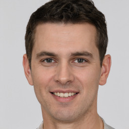 Joyful white young-adult male with short  brown hair and brown eyes