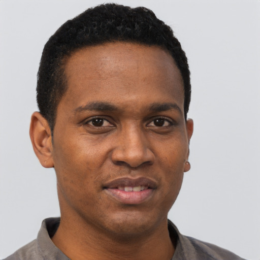 Joyful black young-adult male with short  black hair and brown eyes