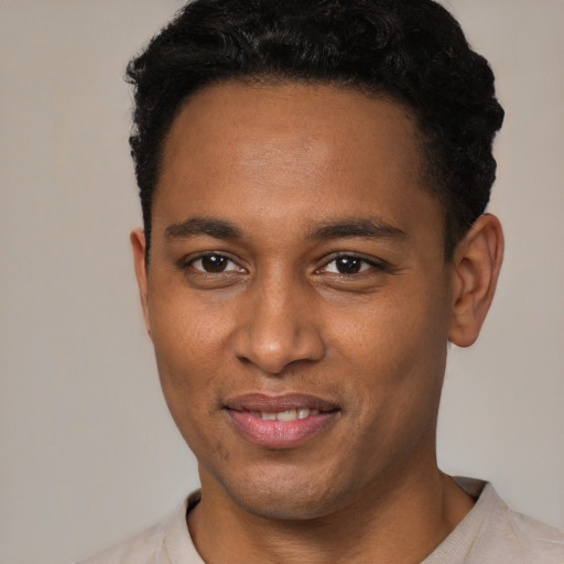 Joyful black young-adult male with short  black hair and brown eyes