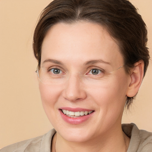 Joyful white adult female with medium  brown hair and grey eyes