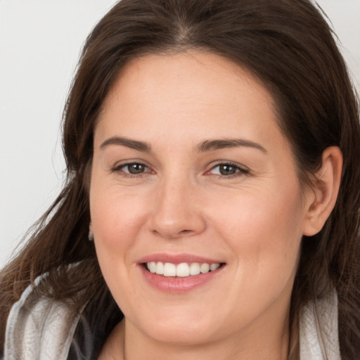 Joyful white young-adult female with long  brown hair and brown eyes