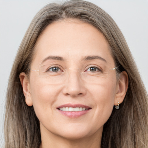 Joyful white adult female with long  brown hair and grey eyes