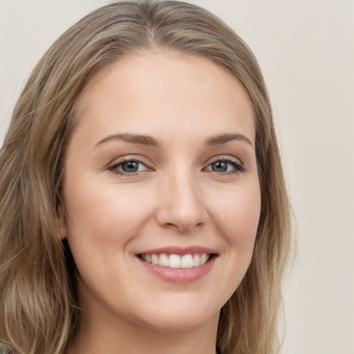 Joyful white young-adult female with long  brown hair and green eyes