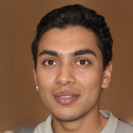 Joyful latino young-adult male with short  black hair and brown eyes