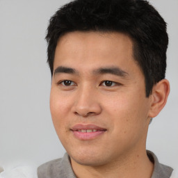 Joyful asian young-adult male with short  black hair and brown eyes