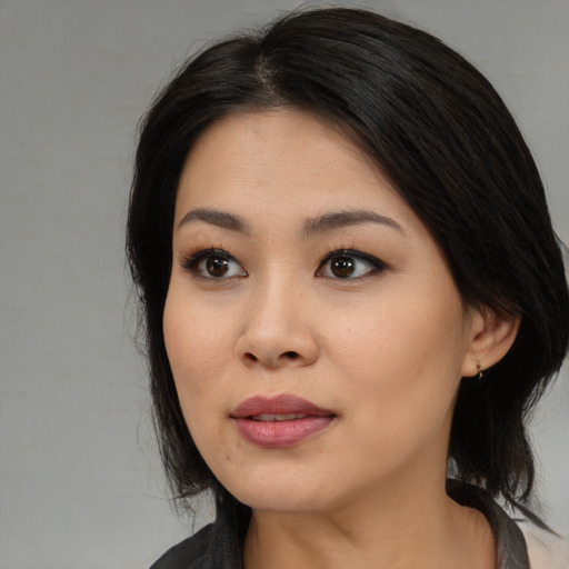 Joyful asian young-adult female with long  black hair and brown eyes