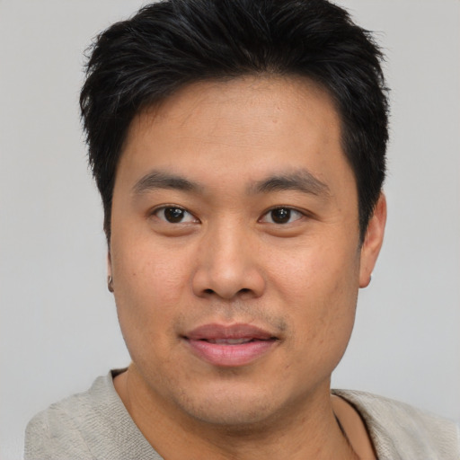 Joyful asian young-adult male with short  brown hair and brown eyes