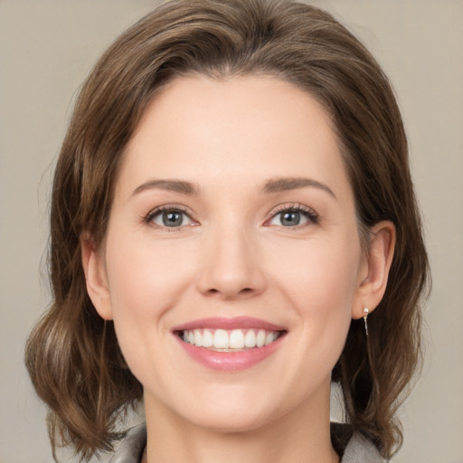 Joyful white young-adult female with medium  brown hair and grey eyes