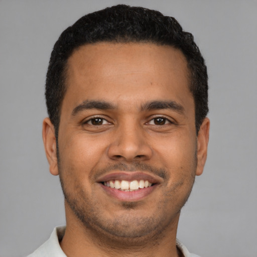 Joyful latino young-adult male with short  brown hair and brown eyes