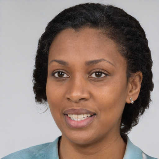 Joyful black young-adult female with long  brown hair and brown eyes