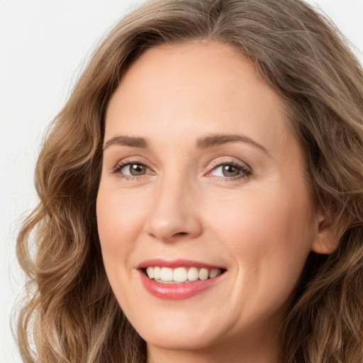 Joyful white adult female with long  brown hair and green eyes