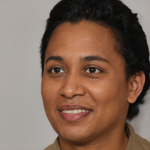 Joyful black young-adult female with short  brown hair and brown eyes