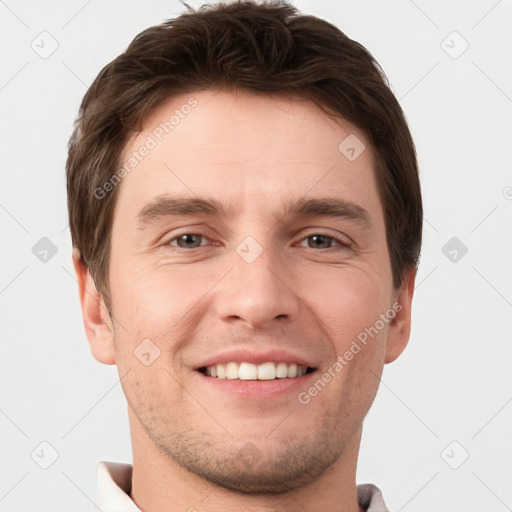 Joyful white young-adult male with short  brown hair and grey eyes