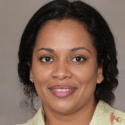 Joyful black adult female with medium  brown hair and brown eyes