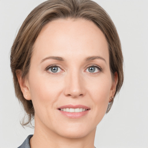 Joyful white young-adult female with medium  brown hair and grey eyes