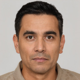 Joyful latino adult male with short  black hair and brown eyes