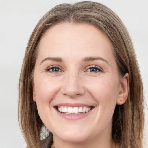 Joyful white young-adult female with long  brown hair and grey eyes