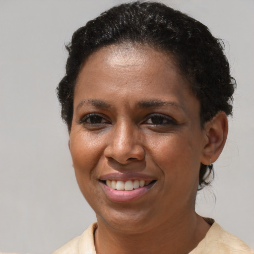 Joyful black adult female with short  brown hair and brown eyes