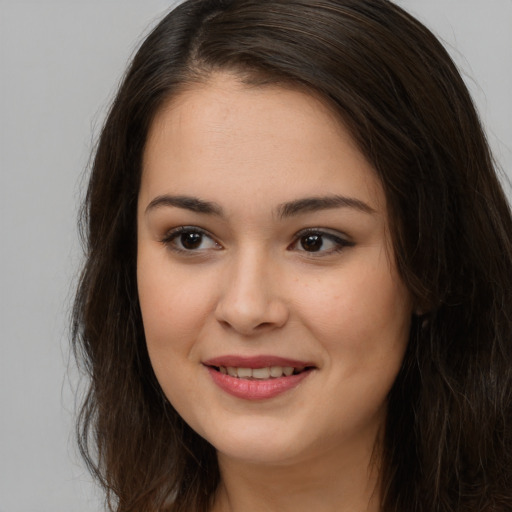 Joyful white young-adult female with long  brown hair and brown eyes