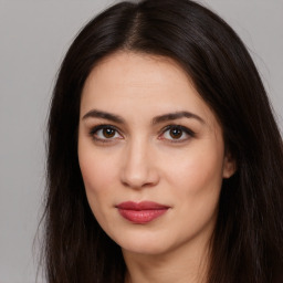 Joyful white young-adult female with long  brown hair and brown eyes