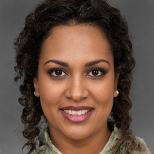 Joyful black young-adult female with long  brown hair and brown eyes