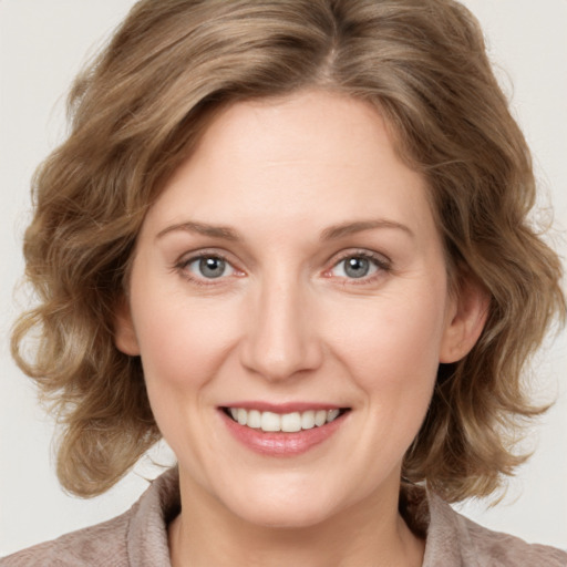 Joyful white young-adult female with medium  brown hair and blue eyes