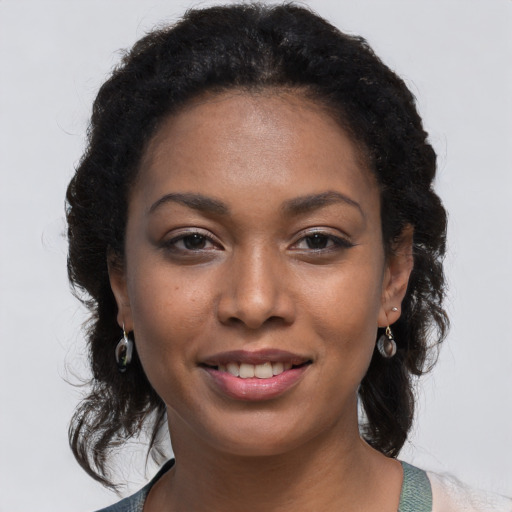 Joyful black young-adult female with long  brown hair and brown eyes