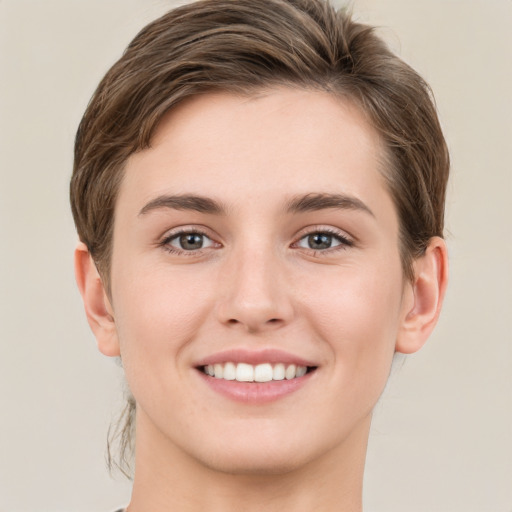 Joyful white young-adult female with short  brown hair and green eyes