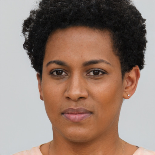 Joyful black young-adult female with short  black hair and brown eyes