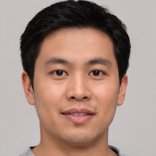 Joyful asian young-adult male with short  brown hair and brown eyes