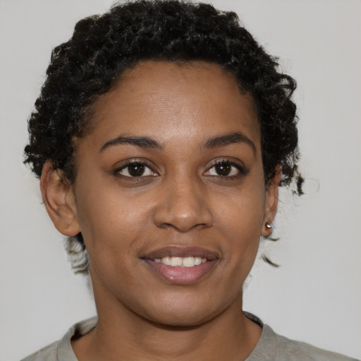 Joyful black young-adult female with short  brown hair and brown eyes
